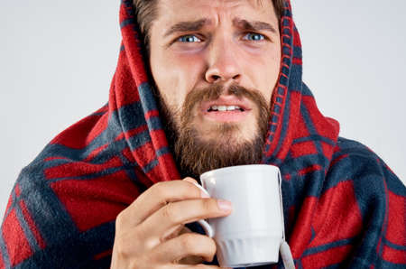 cold man with blanket warming drink health problemの写真素材