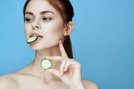 woman with bare shoulders cucumber vitamins health blue backgroundの写真素材