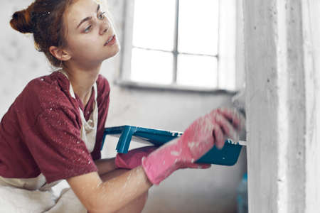 woman with brush in hands paint inside home interior renovationの写真素材