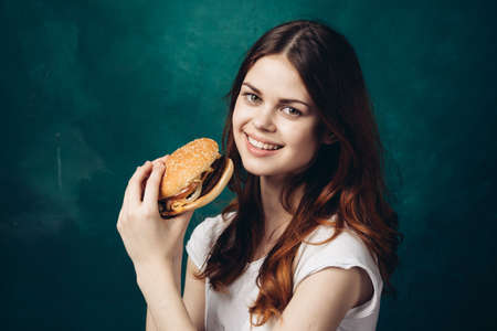 cheerful woman eating hamburger snack close-up lifestyleの写真素材