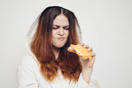 red-haired woman eating a sandwich snack lunchの写真素材