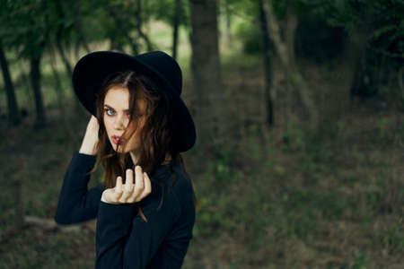woman witch in black hat in the forest posing fantasyの写真素材