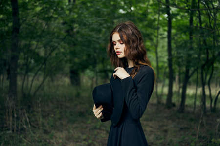 woman in the forest in a black hat gothic style Witch costumeの写真素材