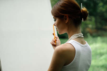 woman outdoors painting a picture creative art landscapeの写真素材