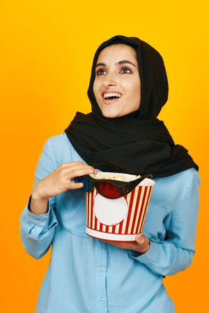 woman in black hijab with popcorn hands studio lifestyleの写真素材