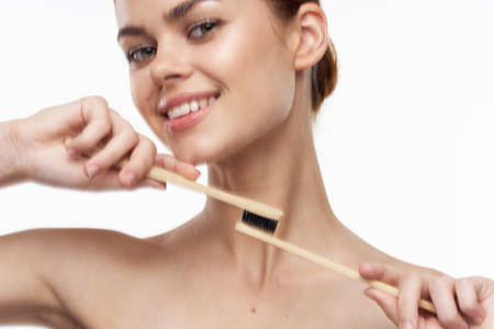 cheerful woman with bare shoulders toothbrushes hygiene oral careの写真素材