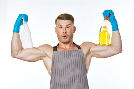 sporty muscular man wearing an apron detergent cleaningの写真素材