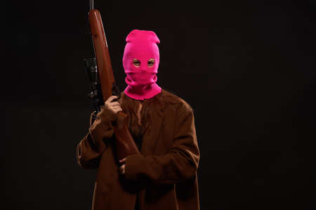 woman with gun in hand pink mask crime danger shooterの写真素材