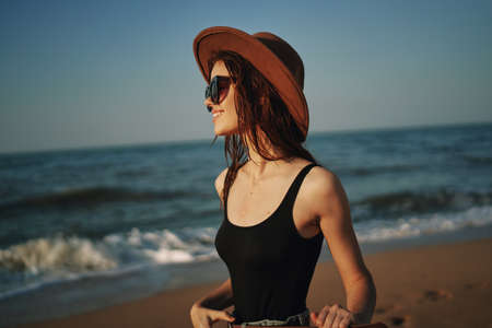 pretty woman in hat walking on the beach ocean travelの写真素材
