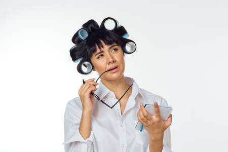 Woman in white coat curlers on her head homeworkの写真素材
