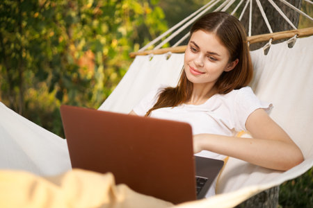 woman with laptop lies in hammock freelance travel