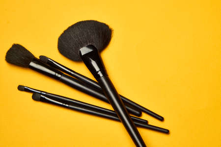 cosmetics mascara brushes decoration accessories yellow backgroundの写真素材