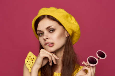 glamorous woman in yellow hat glasses posingの写真素材