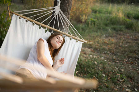 woman relaxing in nature in a hammock garden fresh airの写真素材
