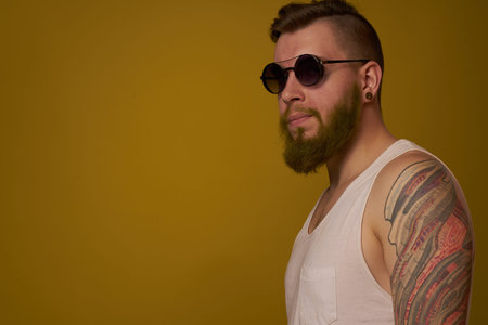 man in a white t-shirt tattoos on his arms fashion glasses modern style