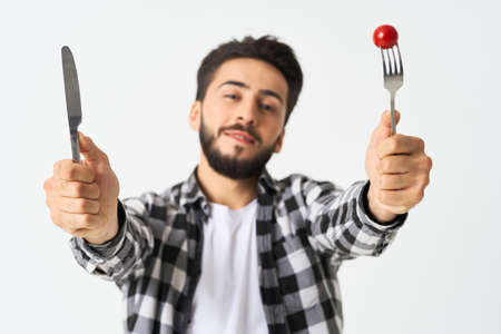 bearded man with kitchen utensils cherry tomatoes snackの写真素材