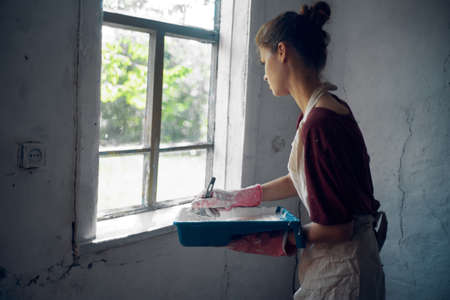 woman in aprons paints window home renovation interiorの写真素材