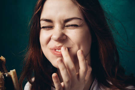 woman eating hamburger fast food snack close-upの写真素材