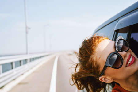 woman looking out of car window wearing sunglasses travel lifestyleの写真素材