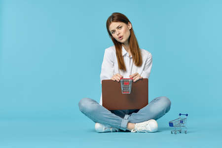 woman with laptop sitting on the floor learning student technology blue backgroundの写真素材