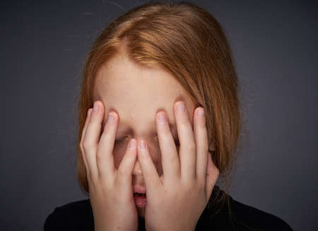 red-haired girl with freckles on her face in a black sweater posingの写真素材