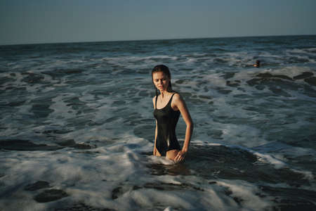 Cheerful woman black swimsuit ocean nature summer tanの写真素材