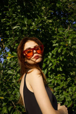 pretty woman wearing sunglasses green leaves summer modelの写真素材
