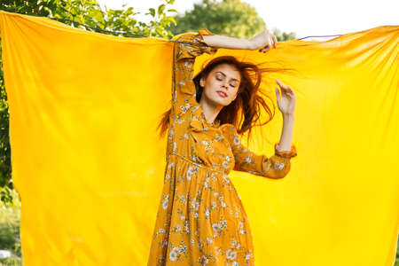 smiling woman in yellow dress posing nature yellow clothの写真素材