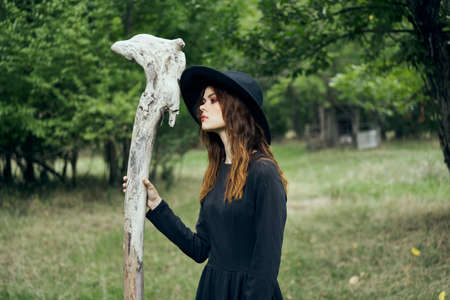 woman in black witch costume in forest nature posingの写真素材