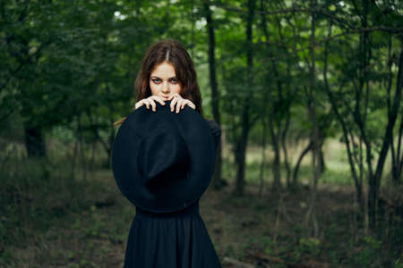 woman in the forest in a black hat gothic style Witch costumeの写真素材