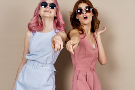 two girlfriends stand side by side fashion clothing glamor posingの写真素材