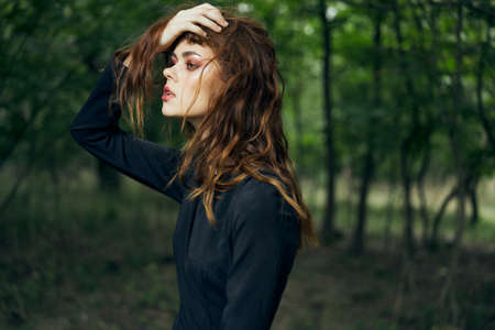 woman in black dress in the forest Halloween Witch costumeの写真素材