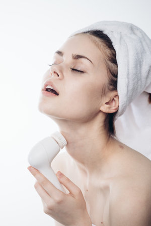 pretty woman with towel on head close-up facial massage
