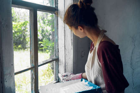 woman with brush paint window home renovation interiorの写真素材