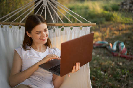 woman with laptop and lies in a hammock vacation nature freelanceの写真素材
