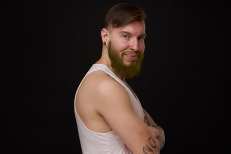 stylish bearded man in a white t-shirt with tattoos on his arms fashion