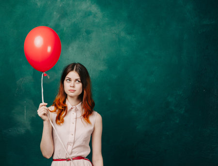 pretty woman in dress red balloon holiday green background