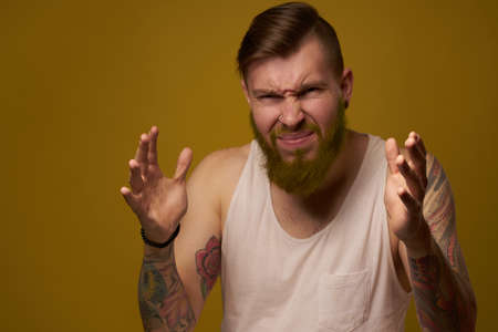 Cheerful bearded man in a white T-shirt with hooligan tattoos on his armsの写真素材