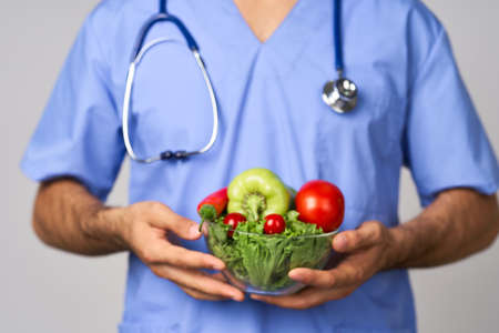 birth bearded male doctor plate with vegetables healthy food treatment caloriesの写真素材
