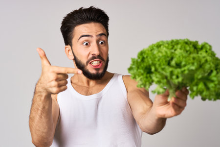 bearded man in white t-shirt lettuce leaf vegetables healthy foodの写真素材