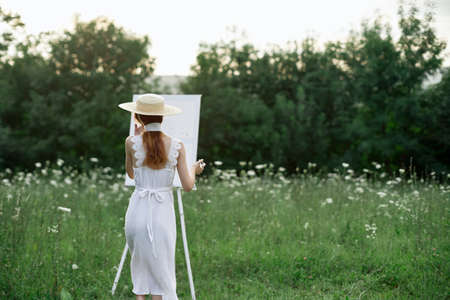 pretty woman in white dress outdoors drawing art creativeの写真素材