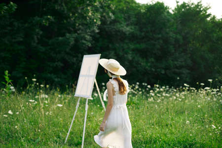 pretty woman in white dress outdoors easel artの写真素材