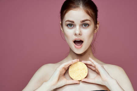 woman with bare shoulders sponge in hands clean skin hygieneの写真素材