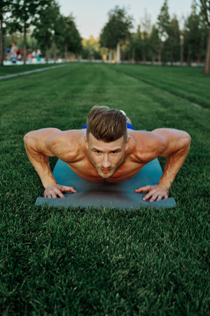 sports muscular man doing fitness crossfit in the park
