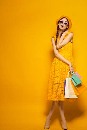 smiling woman in a yellow hat Shopaholic fashion style isolated backgroundの写真素材