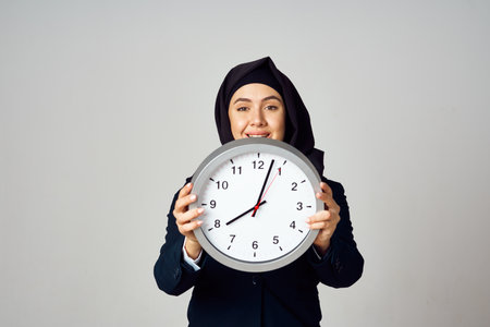 muslim woman with clock in hands office work lifestyleの写真素材