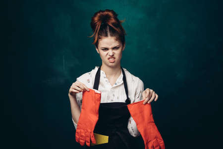woman with rubber gloves in apron cleaning houseworkの写真素材
