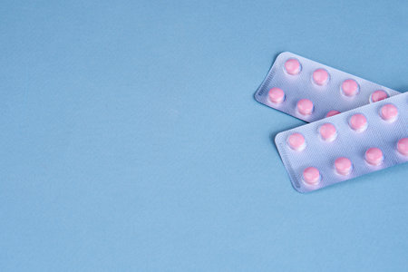 pink pills in packs vitamins pain reliever blue backgroundの写真素材