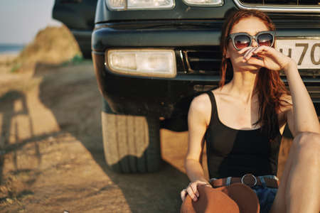 woman in sunglasses near car travel summer vacation landscapeの販売画像
