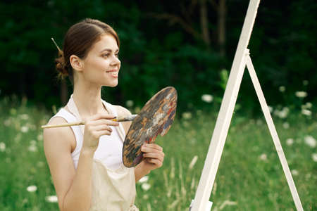 cheerful woman artist painting a picture outdoors creative artの写真素材